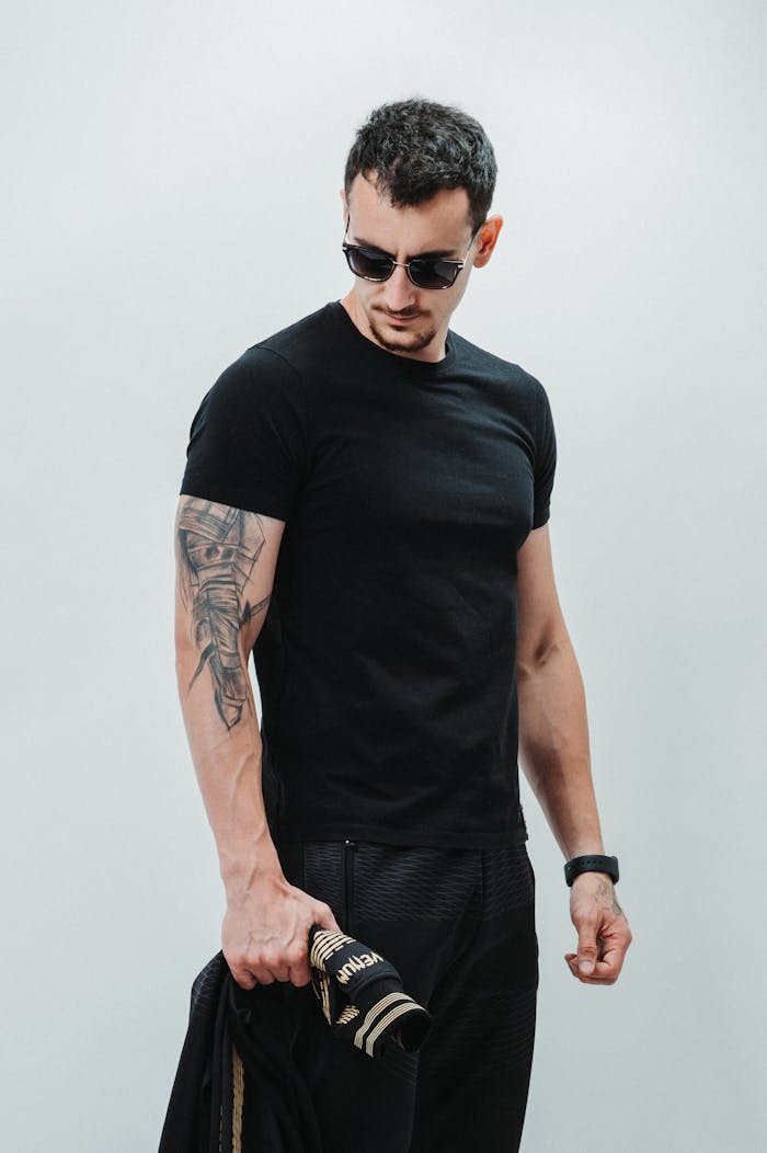 our-experience Portrait of a man wearing sunglasses and a black t-shirt, showcasing modern fashion.