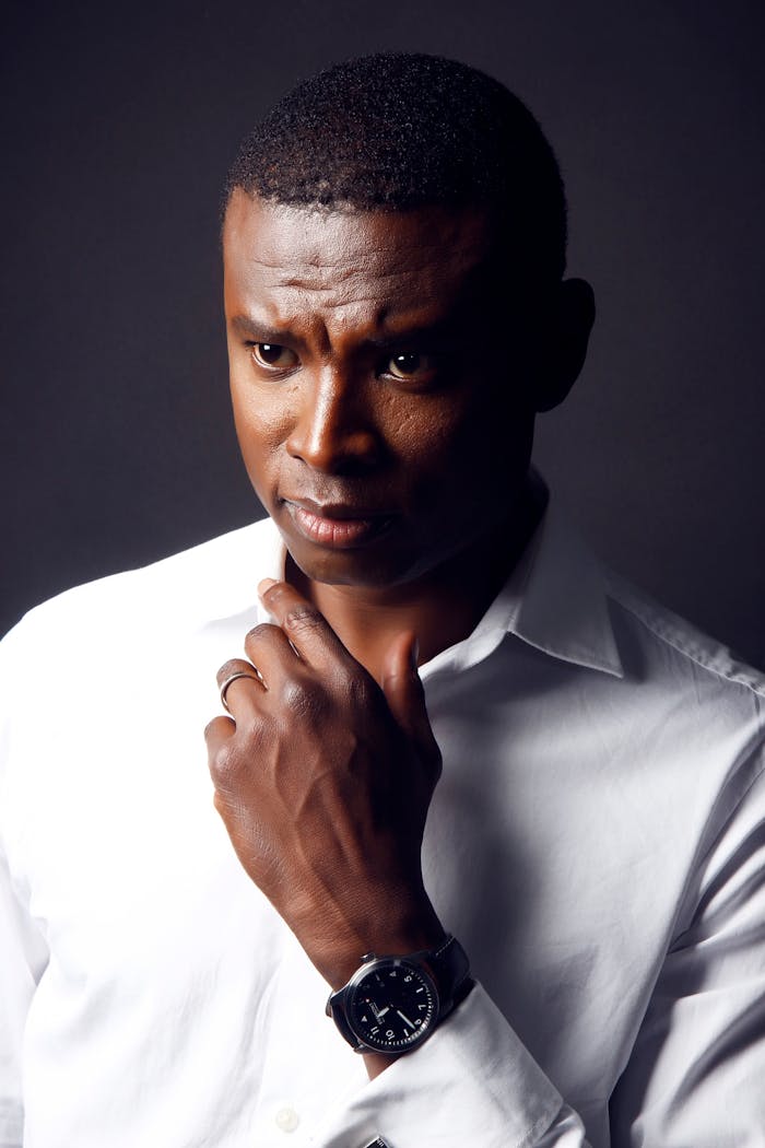 gallery-2 Portrait of a thoughtful man in a crisp white shirt with a serious expression.